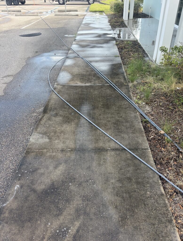 Sidewalk before pressure washing - dirt and stain buildup